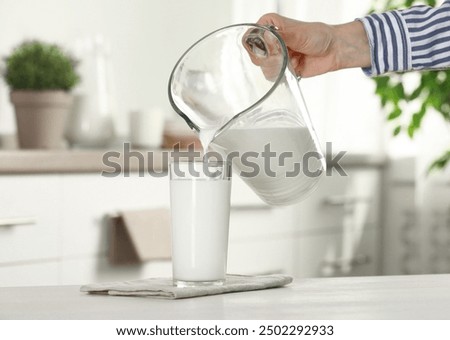 Image, Stock Photo Woman pouring fresh milk from bottle to enamel mug while having refreshment in garden