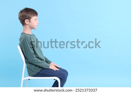 Similar – Image, Stock Photo Boy sitting on a sofa with headphones on his head and using the laptop