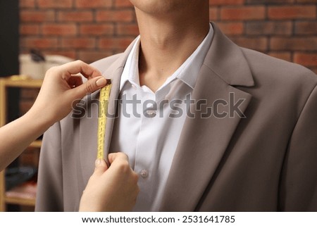 Similar – Image, Stock Photo Closeup of female tailor cuting out checkered fabric with a paper pattern to make out a shirt