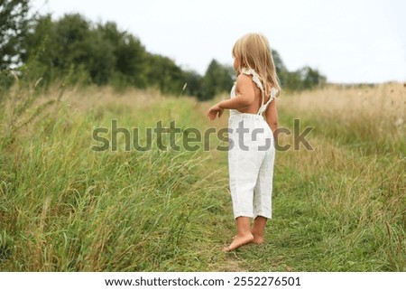 Similar – Image, Stock Photo Little girls walking barefoot on the sand and caring a picnic basket together. Summer leisure, love and friendship.