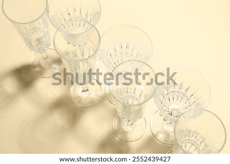 Similar – Image, Stock Photo empty wine glasses. Beautiful new glasses for wine from glass stand in even rows on a wooden table in a restaurant. selective focus