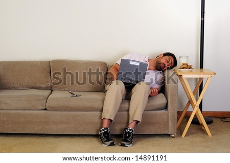 Boring computer nerd falls asleep on couch while using internet