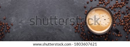 Horizontal banner with cup of coffee and coffee beans on dark stone background. Top view. Copy space - Image