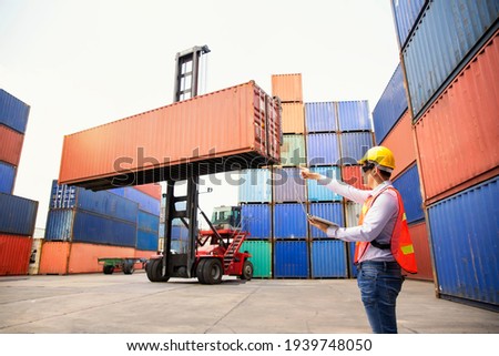 Foreman or Operator Ordering of moving containers with laptop computer. Foreman looking forward on Forklifts in the Industrial Container Cargo freight ship. Look forward. Foto stock © 