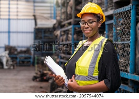 Engineers or technicians are inspecting auto parts in warehouses and factories. African american woman holding a flipchart in parts warehouse.