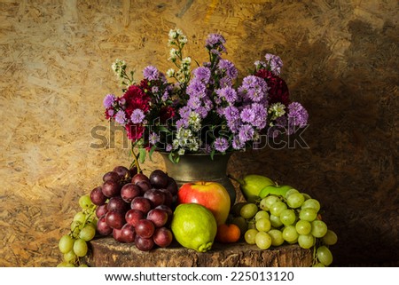 Still Life Fruits were placed on the timber with a beautiful vase of flowers.