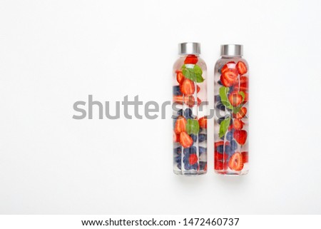 Similar – Image, Stock Photo Tasty infused water in bottle with drinking straw and ingredients: lime, strawberry and mint leaves at white background