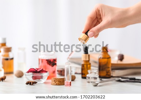 Woman preparing perfume on table