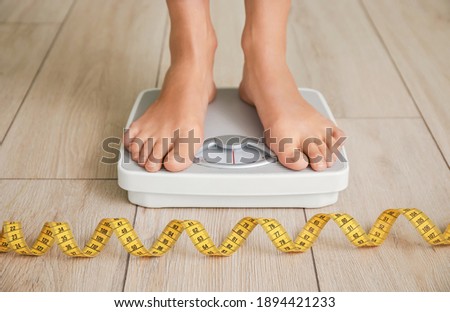 Young woman measuring her weight at home Foto stock © 