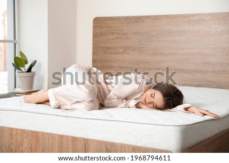 Morning of beautiful young woman lying on bed with soft mattress