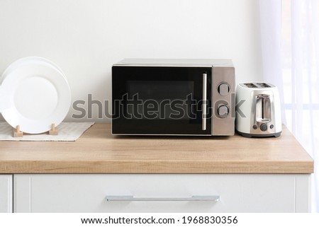 Microwave oven with toaster on kitchen table