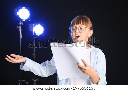 Little actress on dark background