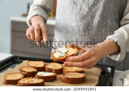 Female chef preparing toasts with cheese on kitchen table, closeup 商業照片 © 
