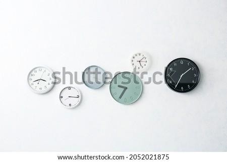 Different stylish clocks hanging on light wall ストックフォト © 