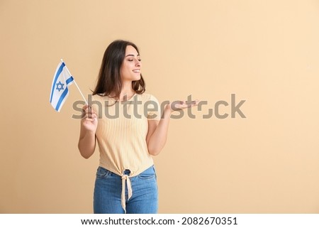 Young woman with the flag of Israel showing something on color background Stok fotoğraf © 
