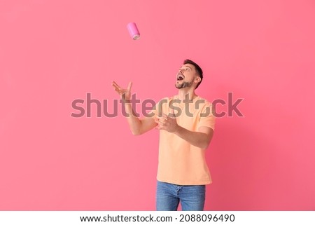 Handsome man catching can of soda on color background Stock foto © 