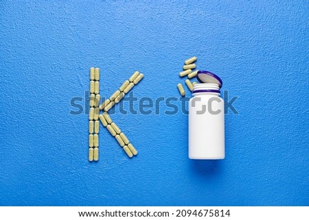Bottle and letter K made of pills on color background Stock fotó © 