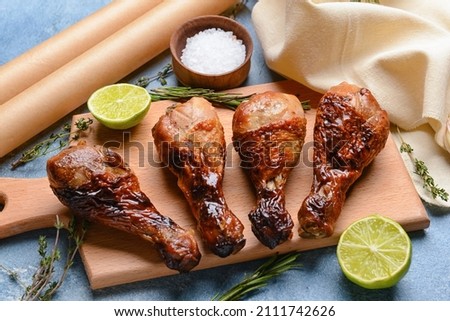 Board with tasty cooked chicken drumsticks on color background Stock fotó © 