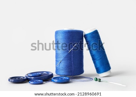 Sewing thread spools, needle, pins and buttons on white background Imagine de stoc © 