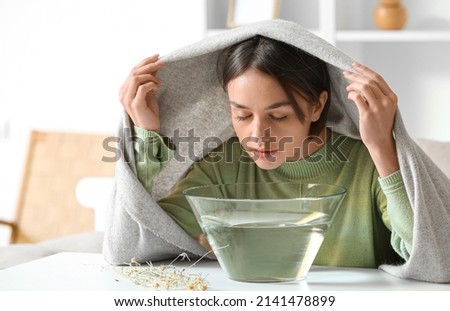 Young woman doing steam inhalation at home to soothe and open nasal passages 商業照片 © 