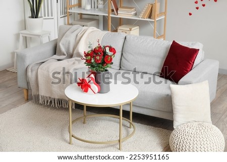 Interior of living room decorated for Valentine's Day with sofa, flowers and gifts Foto stock © 