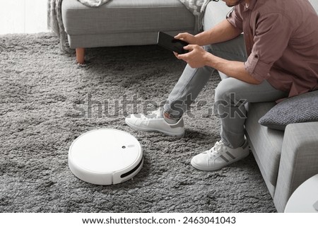 Similar – Image, Stock Photo A robot vacuum cleaner cleans the apartment diligently and independently and makes household chores easier