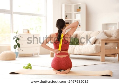 Similar – Image, Stock Photo Woman with resistance band on wrists working out at home