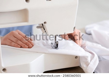 Similar – Image, Stock Photo Closeup of female tailor cuting out checkered fabric with a paper pattern to make out a shirt