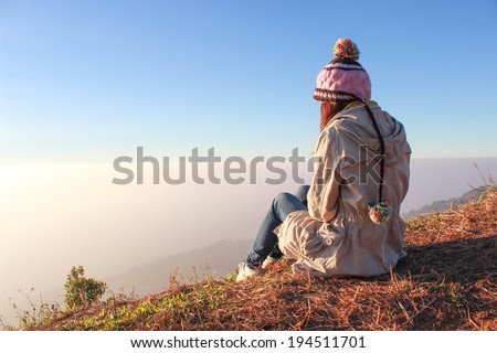 Woman sitting on mountain mist