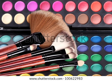 Multi colored makeup brushes and make-up eye shadows