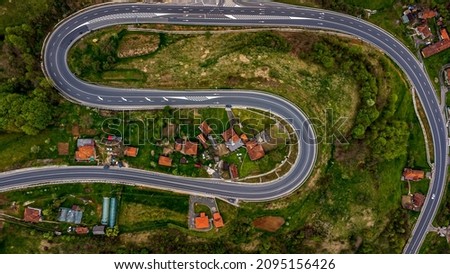 Aerial view of a curved road seen with cars driving. Photo taken on 1st of May 2021, near Brad city, Hunedoara County, Romania. Imagine de stoc © 