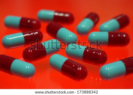 red and blue capsule on red backround