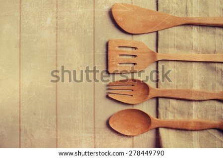wood kitchen tools on the old wood kitchen cutting board with textured paper background