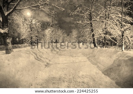 Aged photo in retro vintage style of the long snowy street at the winter night with the moon. Used original photo. Russia, Kaluga town.
