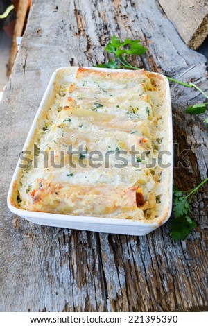 baked cannelloni on old boards. Delicious dinner.