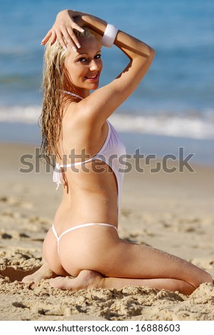 Pretty blonde bikini girl posing on beach