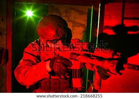 Special forces soldier or contractor during night mission/operation (red and green light for underline the atmoshpere)