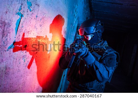 Special forces/ anti-terrorist police unit/private military contractor during night CQB hostage rescue raid/operation/mission (red and blue light for underline the atmosphere)