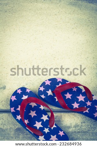 Fourth of July Rubber Sandal Flip-Flop Thongs on Wood Boardwalk and White Sand background with room or space for copy, text, your words.  Vintage instagram, vertical warm tone