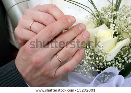 Two rings on fingers newly married, a bouquet of yellow roses in a hand