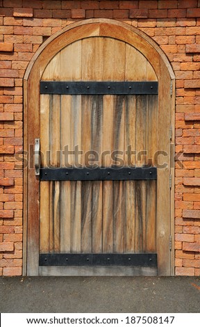 Wood arch door on red brick wall