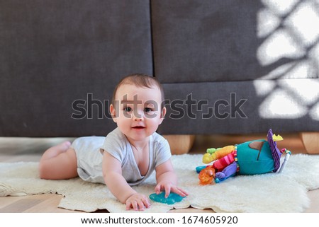 Similar – Image, Stock Photo 6 month old baby playing wearing black and white playing with colorful ring stack toy