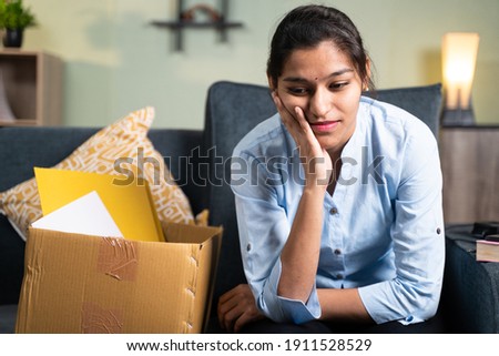 Worried young business woman sitting sadly on sofa at home due to loss of job, employment or fired from the work ストックフォト © 