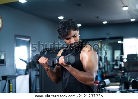 Young man exercsing with dumbbells for biceps at gym - concept of bodybuilding, fitness training center, healthy lifestyle, weight lifting and recreational activity. Stock foto © 