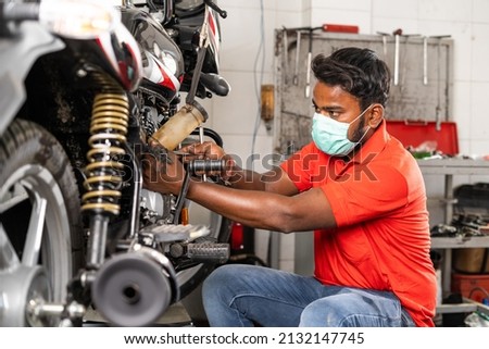 Image, Stock Photo Busy technician in motorcycle workshop