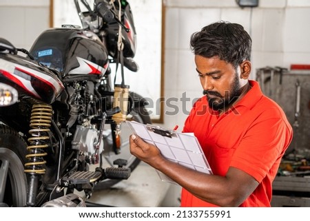 Similar – Image, Stock Photo Busy technician in motorcycle workshop
