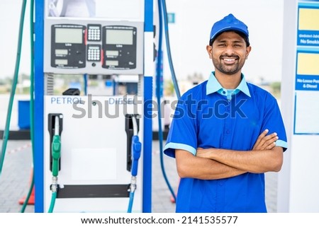 Happy petrol pump worker standing with crossed arms by looking camera at gas filling station - concept of successful, employment and petroleum service. Foto d'archivio © 