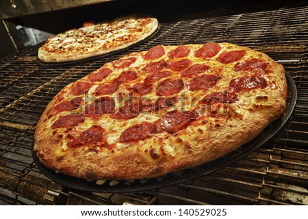 Delicious and fresh pepperoni pizza coming out of the oven.