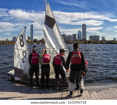 CAMBRIDGE - OCTOBER 1: Members of the Harvard Crimson sailing team preparing their sailing boat for a competition in the Charles River on a sunny autumn day of October 1, 2013 in Cambridge, MA, USA.