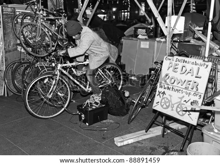 NEW YORK, NY - NOVEMBER 12: Member of the Occupy Wall Street movement pedals a bike to generate electricity for the camp. Occupy Wall Street goes green. November 12, 2011